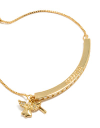 A close-up highlights the angel charm crafted from gold plated metal with cubic zirconia wings and celestial details on this statement toggle bangle close up view - link has visual effect only