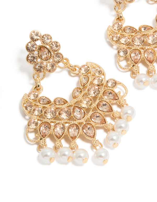 Showcasing gold diamante and pearl statement drop earrings close up view