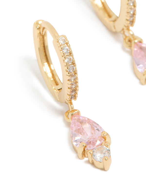 Featuring dainty huggie earrings with pink cubic zirconia, gold plated finish close up view