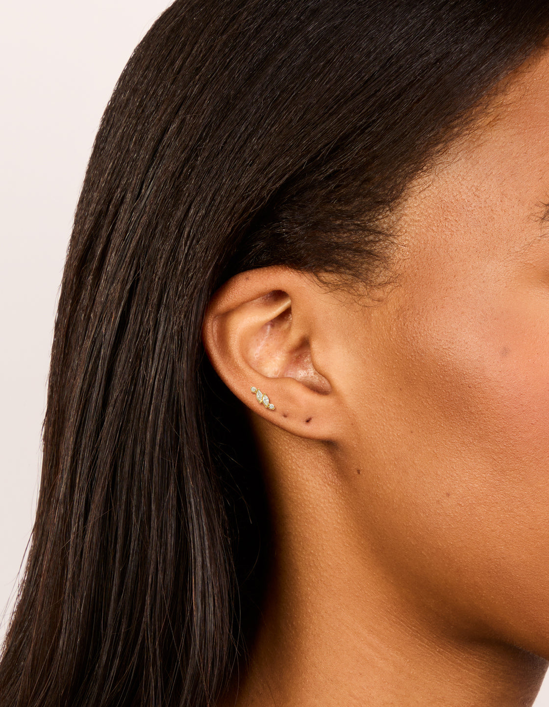 Discover dainty vine design flat back stud earrings crafted from gold plated surgical steel featuring marquise cut cubic zirconia stones on ear view
