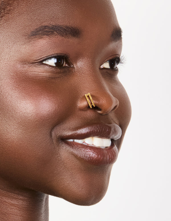Showcasing gold plated surgical steel double hinged nose rings in a pack nose view