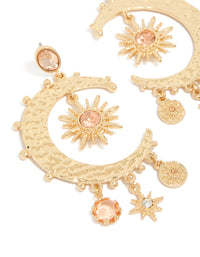 Featuring gold clear and pink diamante celestial moon drop earrings with charm and disc accents close up view - link has visual effect only