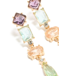 Crafted from gold, these irregular shaped purple and blue diamantes drop earrings feature oval stone cut in a statement style close up view - link has visual effect only