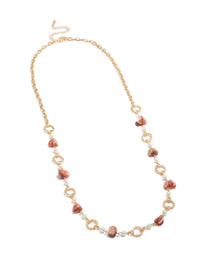 Featuring a gold open circle long statement necklace with beads and pearls in pink coral and white tones front view - link has visual effect only