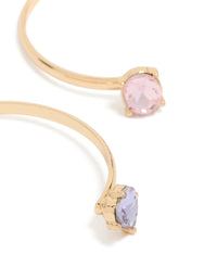 Highlighting gold wrist cuffs featuring pink and lavender diamante embellishments close up view - link has visual effect only