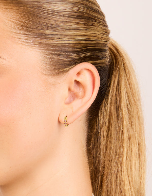 Showcasing waterproof gold plated stainless steel pink cubic zirconia huggie earrings on ear view