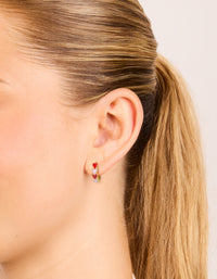 Featuring waterproof gold plated stainless steel red and pink enamel heart huggie earrings in coral on ear view - link has visual effect only