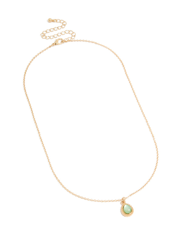 Showcasing a simple teardrop pendant necklace in gold with pale green accents close up view