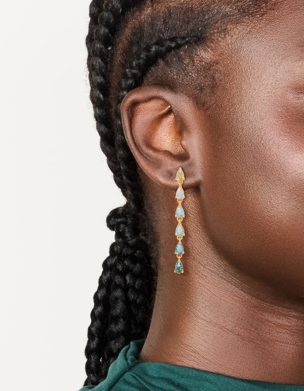 Showcasing gold plated long cubic zirconia drop earrings with aqua accents on ear view