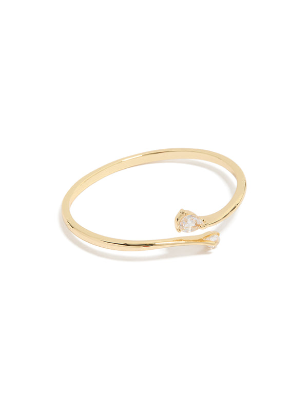 Crafted from gold plated material featuring cubic zirconia flat teardrop open front bangle in statement style front view