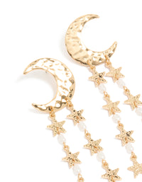 Showcasing gold crescent moon and star drop earrings with celestial charm details, pearl beads, and white accents close up view - link has visual effect only