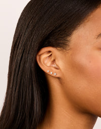 Showcasing sterling silver cubic zirconia starburst earrings in a dainty 3-pack with celestial and ball design, stud closure, and clear accents on ear view - link has visual effect only