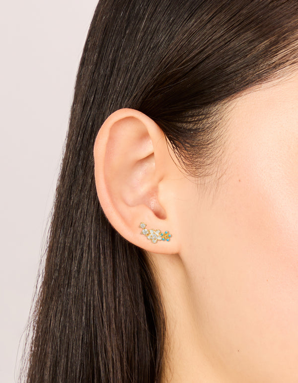 Elegant gold plated sterling silver cubic zirconia flower stud earrings with turquoise and clear details on ear view