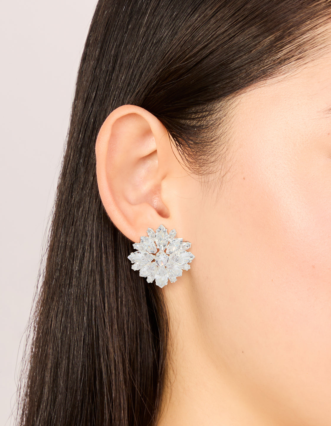 Stunning silver plated cubic zirconia flower cluster stud earrings featuring clear stones on ear view