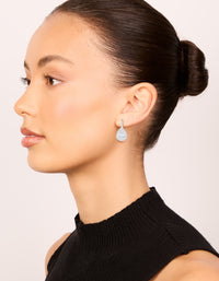 Featuring large hook drop earrings in statement style with cubic zirconia stones and plated finish on model view - link has visual effect only