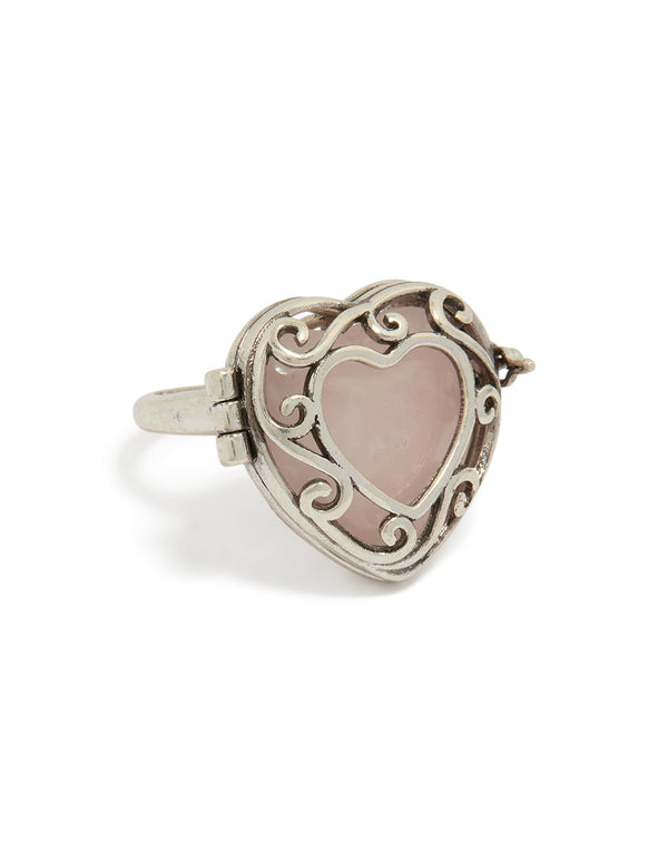 Showcasing an antique silver heart stone locket ring in rosy brown front view
