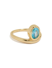 Showcasing a gold plated stainless steel statement ring with oval cut blue cubic zirconia crystal in aqua front view - link has visual effect only
