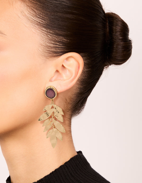 Featuring statement drop earrings with purple beads, textured layered petals in gold on ear view