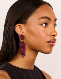 Featuring statement burgundy coated metal petal drop earrings in maroon and gold on model view - link has visual effect only
