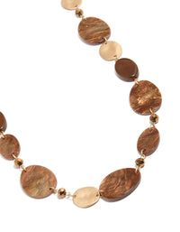 Showcasing a beaded glittery gold statement necklace close up view - link has visual effect only