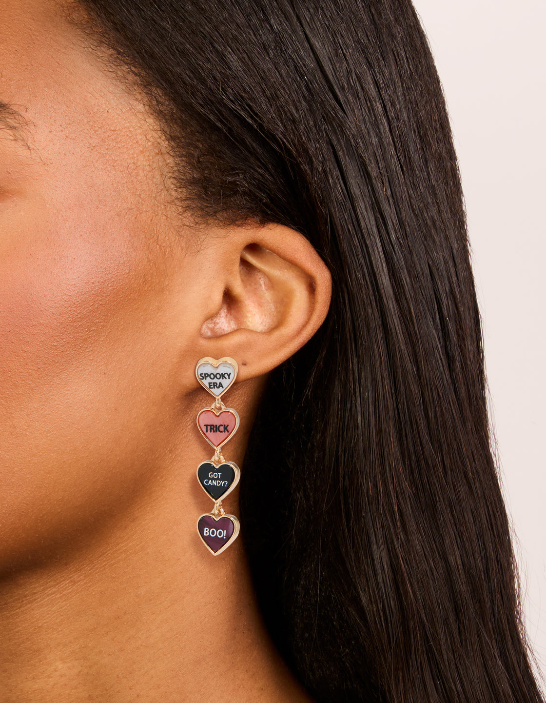 Designed with gold boo and grim drop earrings featuring with heart shaped script elements in maroon, black, and light coral on ear view