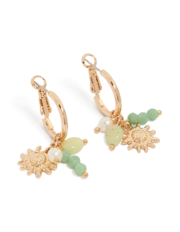 Showcasing dainty huggie earrings with sun charm, green beads, and pearls in gold front view