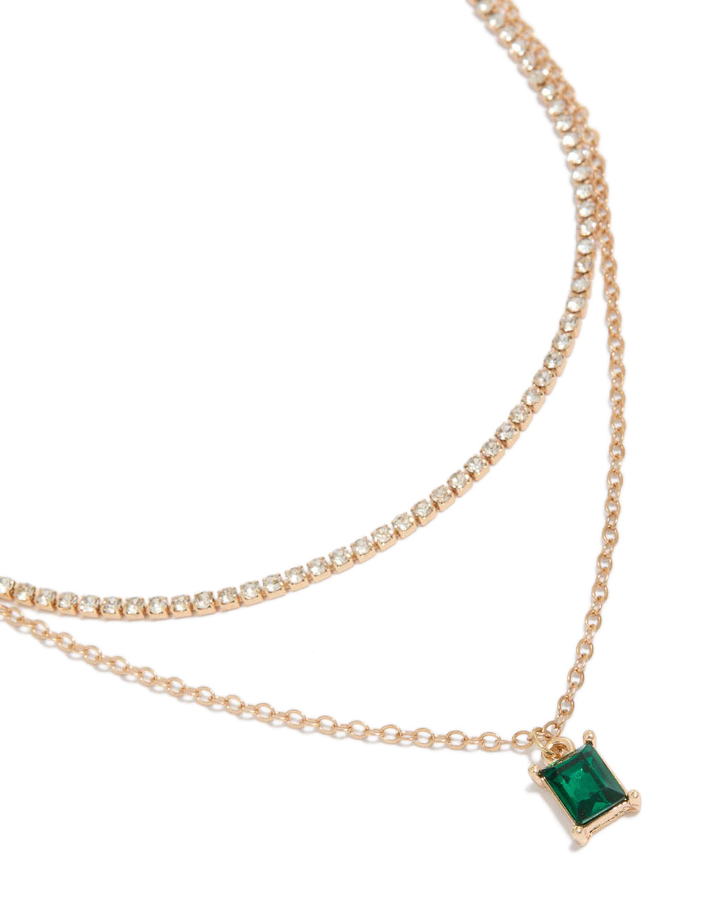 Showcasing a gold cupchain green baguette layered necklace close up view