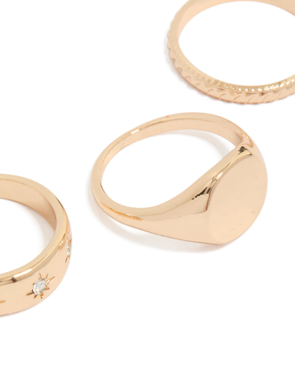 Showcasing celestial star embellishments with signet and textured band designs in gold, 3-pack ring set close up view